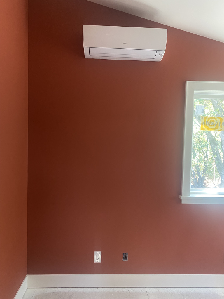 Wall-mounted heat pump air handler in bedroom